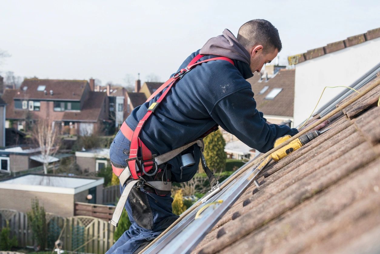 man making the construction for the solar panels high on the roof